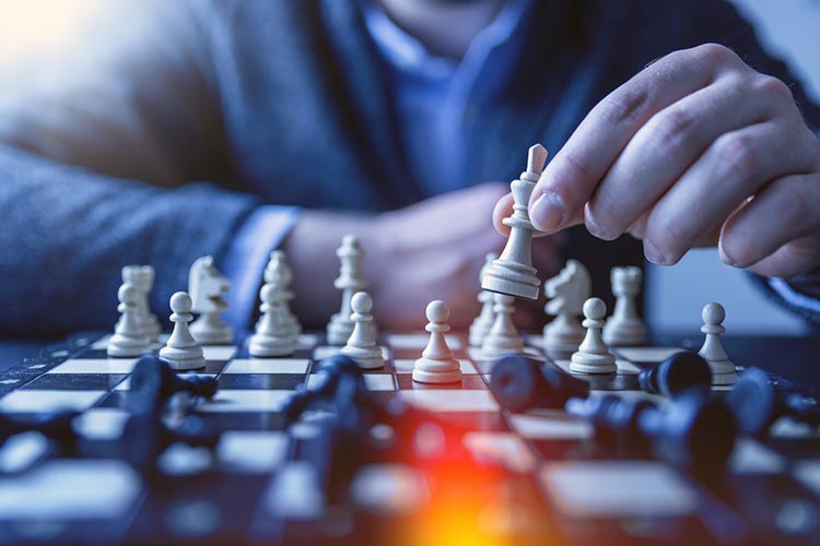 person moving pieces on a chessboard